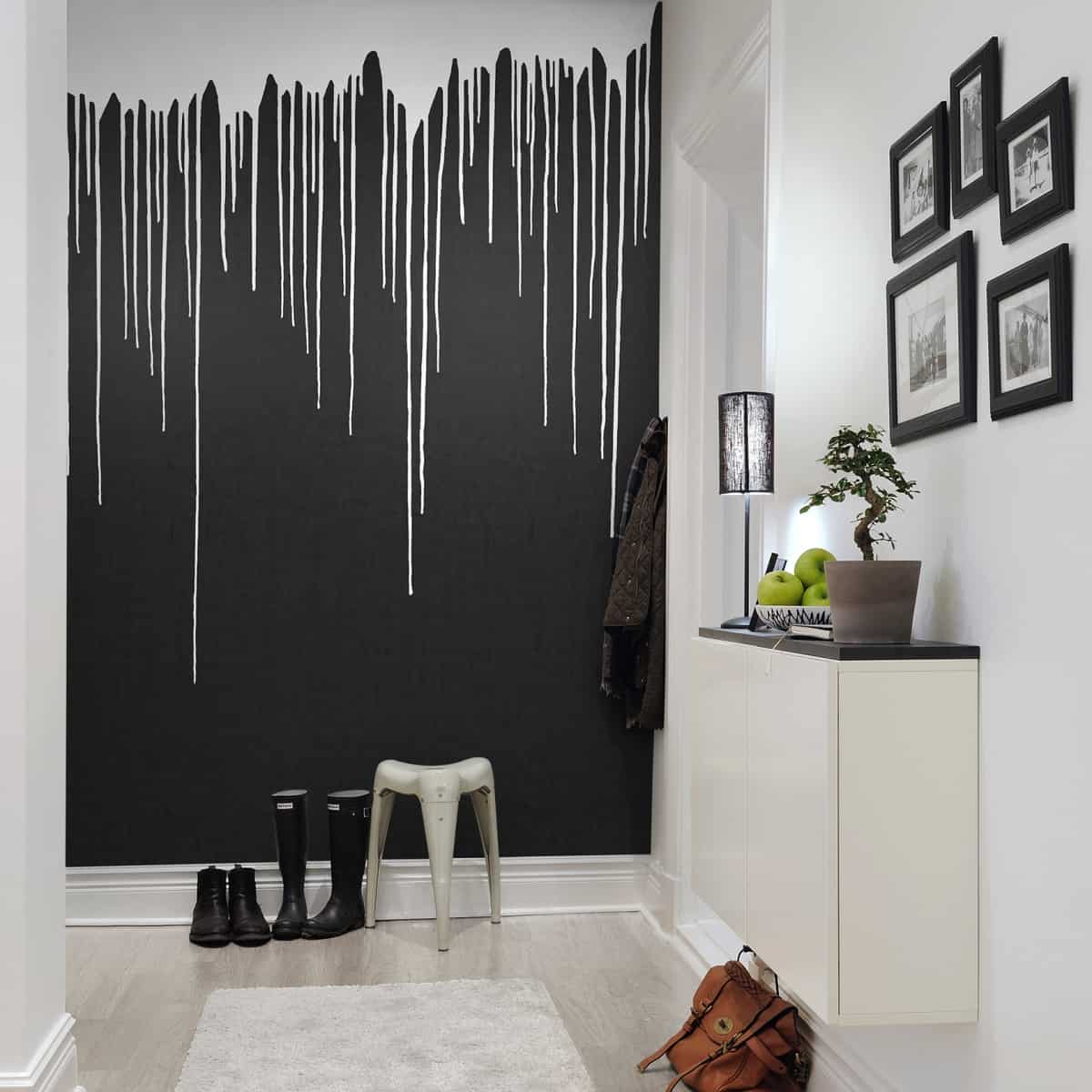 fototapet aplicat pe holul casei cu design de vopsea albă prelinsa pe un zid negru