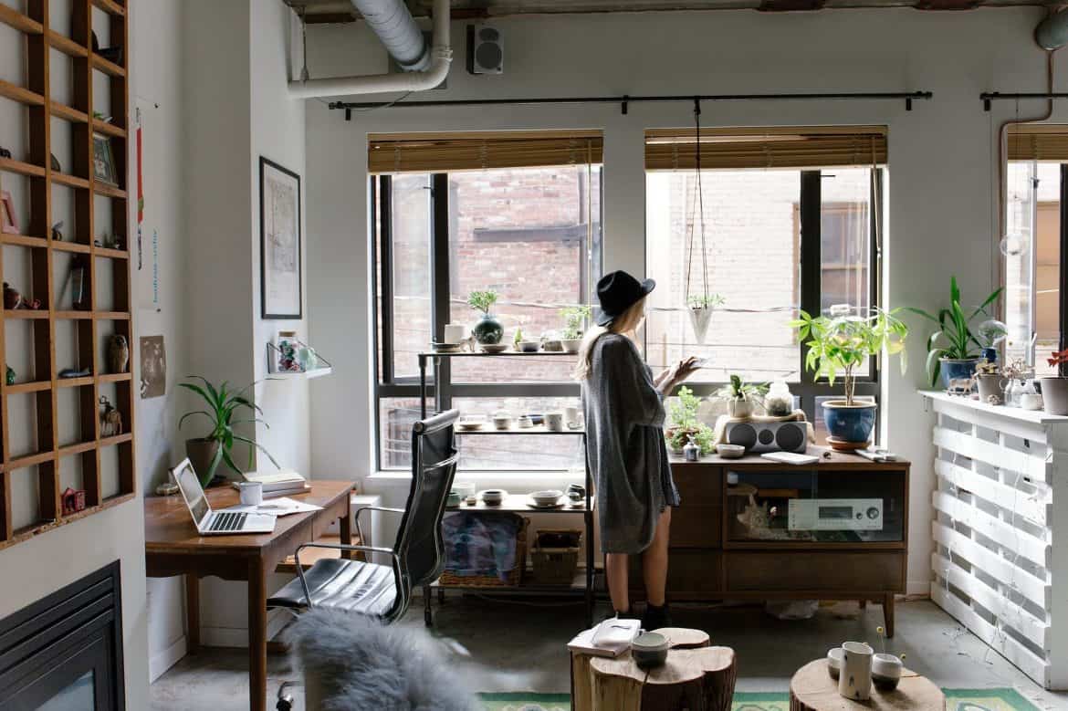 Spațiu de lucru amenajat într-un apartament, aproape de fereastră, cu spații de depozitare, rafturi suspendate și elemente de decor