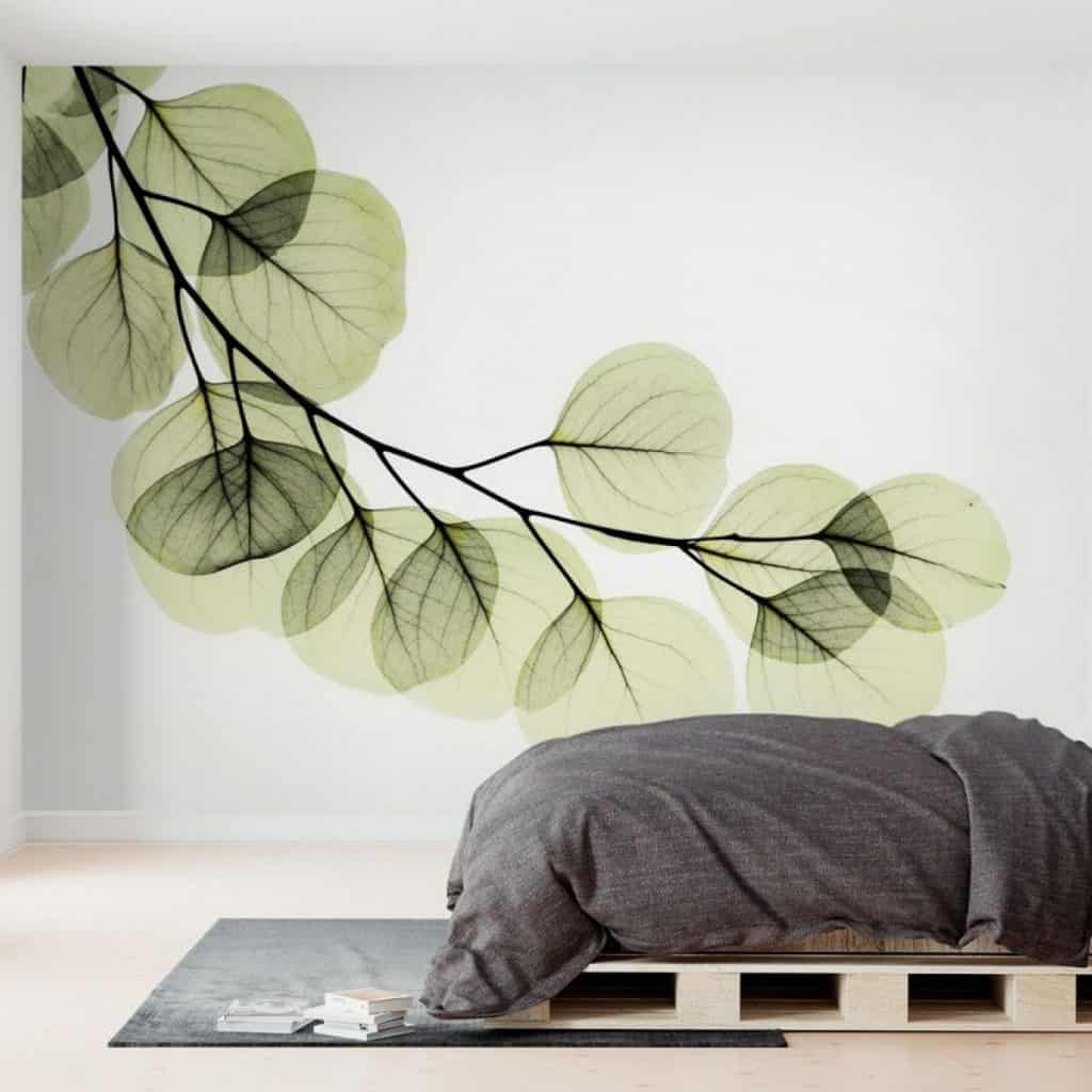 Perete decorat cu fototapet cu frunze verzi translucide, într-un dormitor cu pat dintr-o casa verde
