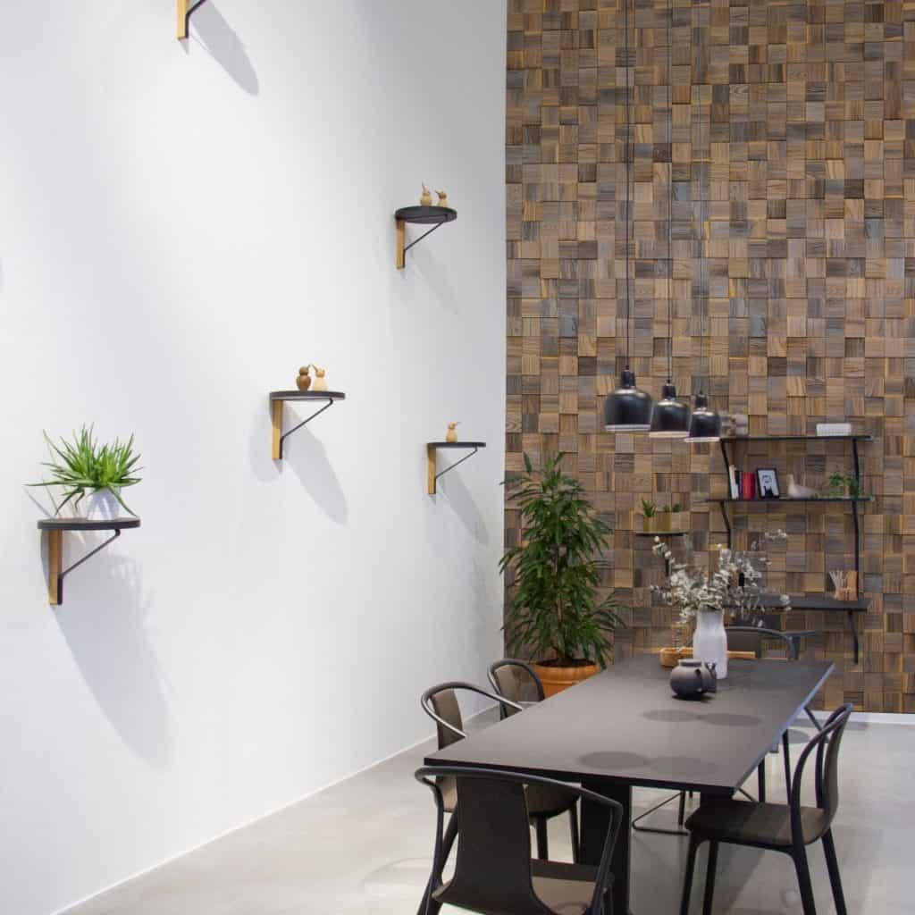 Camera cu perete amenajat cu panouri decorative din lemn, cu polite, masa si scaune și plante decorative