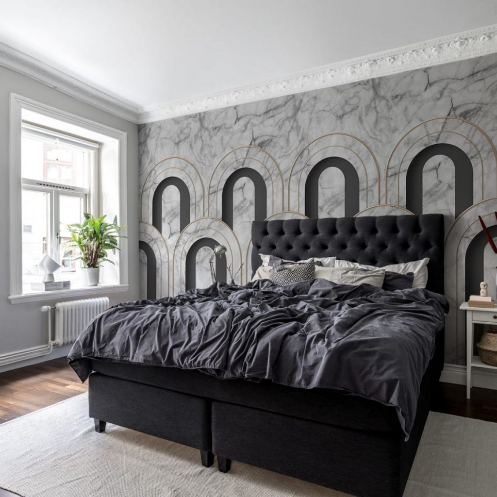 Fototapet 3D Arch Deco, Marble, Rebel Walls, intr-un dormitor cu pat negru, cu fereastra pe care se afla un vas cu planta și o noptiera alba