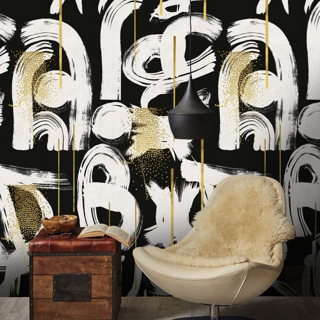 Tapet negru Gestural Abstraction, Mindthegap, pe un perete in fata caruia se afla un fotoliu cu husa din blana si o masa cu carte si vas decorativ