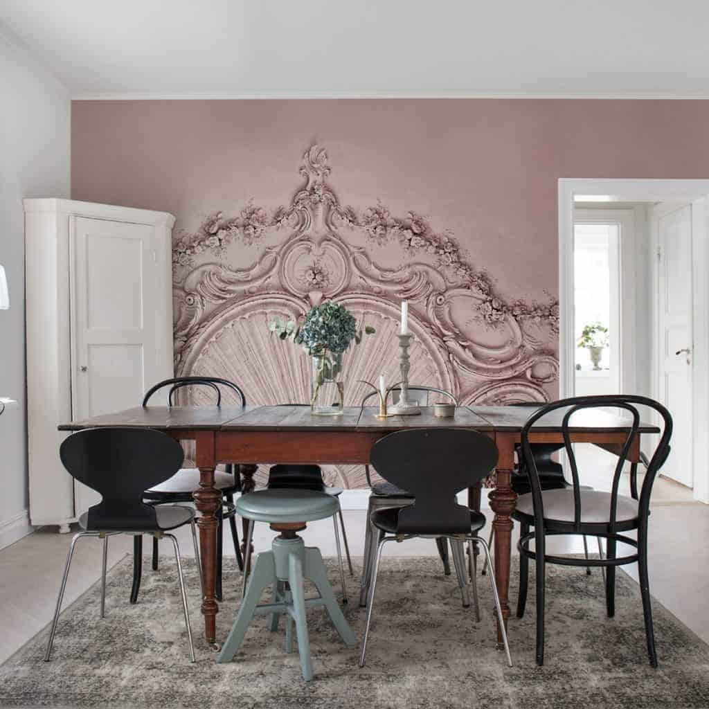 Fototapet 3D Stucco Gloria, Dusty Pink, personalizat, Rebel Walls, intr-un living cu dulap de colt alb, masa cu scaune diferite si covor gri