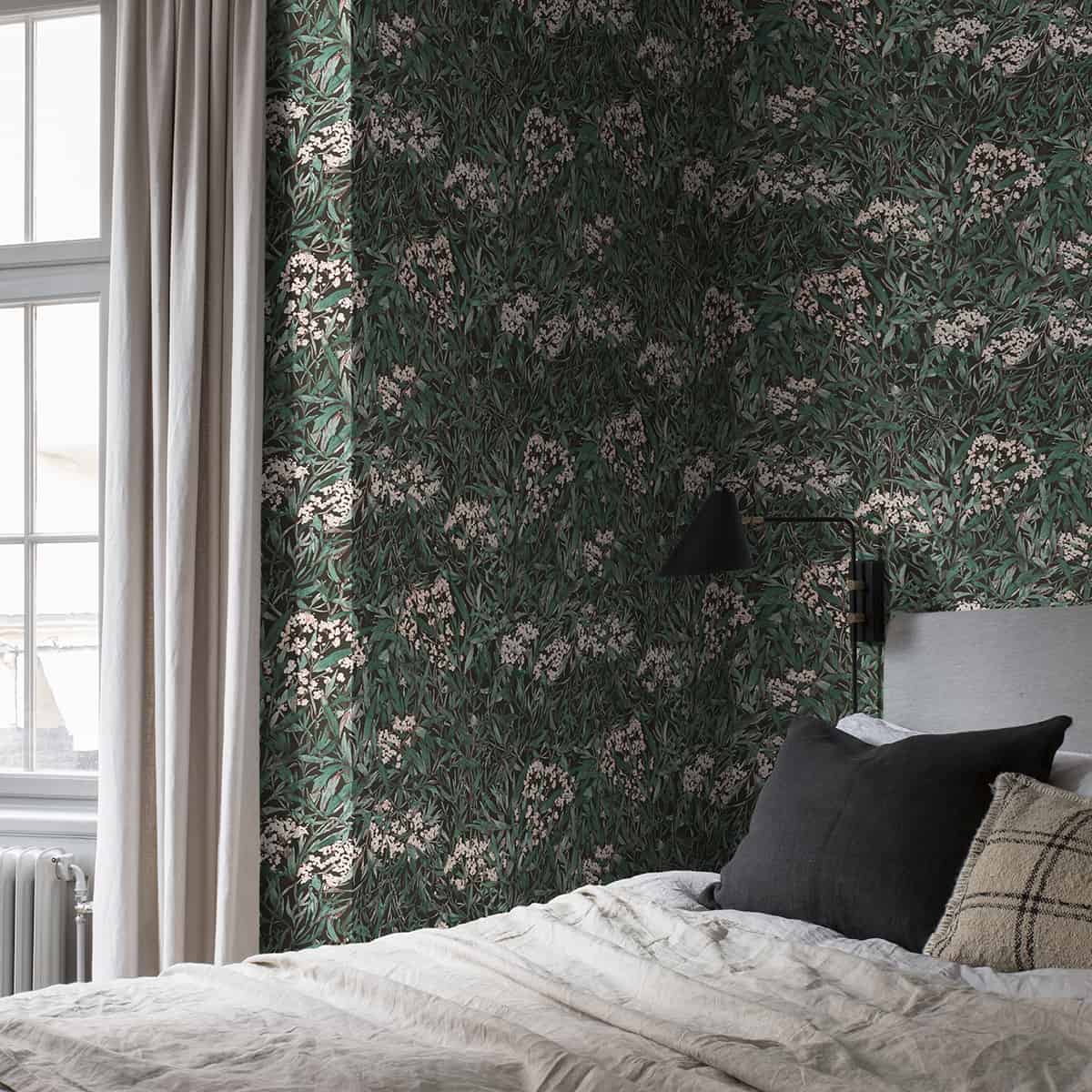 dormitor decorat cu tapet de culoare verde, cu perdele bej si pat cu lenjerie in tonuri de alb, negru si maro