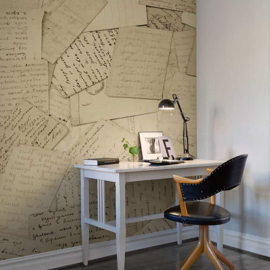 Fototapet cu scrisori vechi aplicat pe un perete in fata caruia se afla o masa de lucru si un scaun