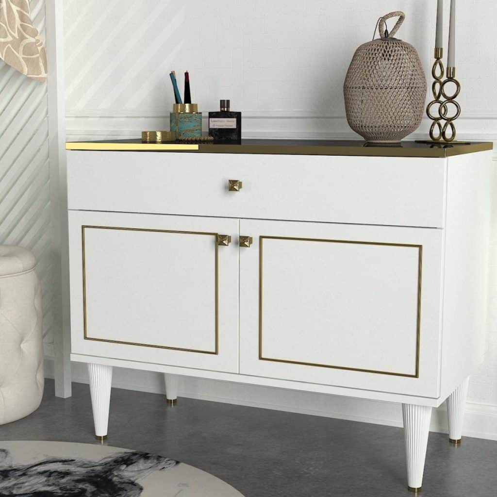 Comoda alba din pal melaminat, cu un sertar si doua usi, pe care se afla obiecte de toaleta, lumanari si obiect decorativ