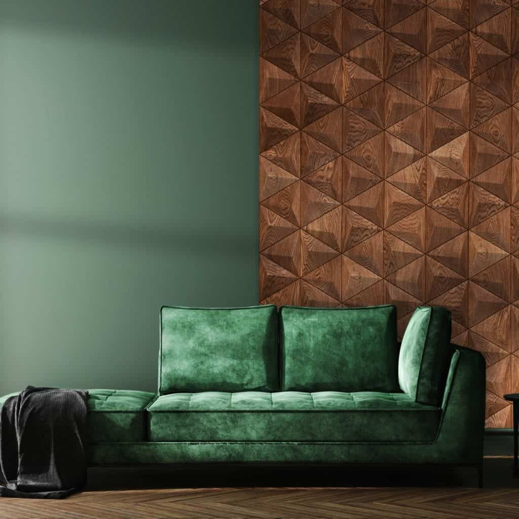 Perete cu panouri decorative din lemn in fata caruia se afla o canapea verde