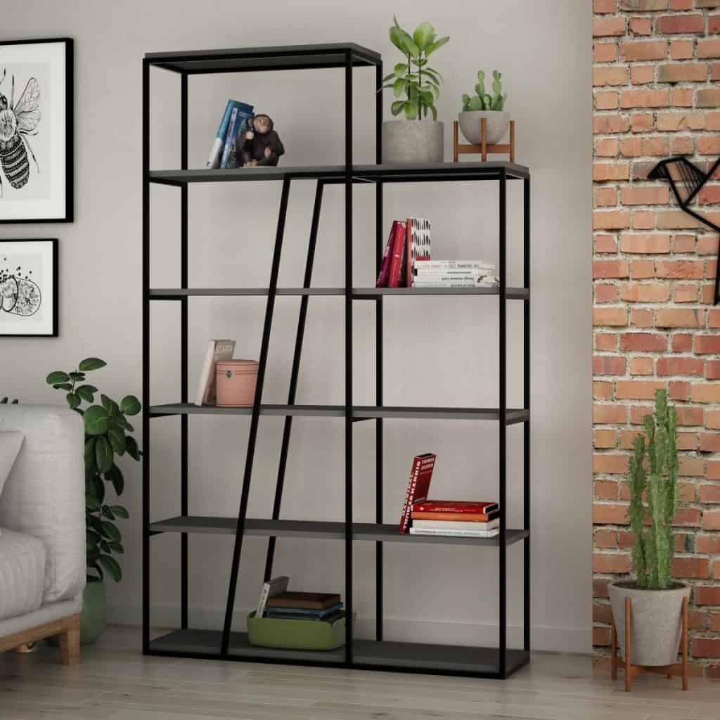 Biblioteca cu carti si obiecte decorative, langa un perete din caramida, planta, fotoliu si doua tablouri
