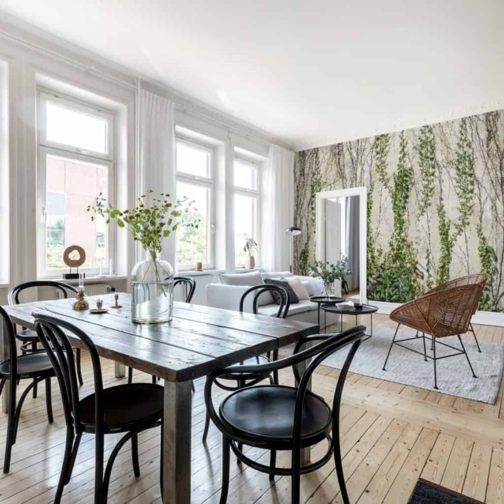Living cu fototapet cu iedera cu canapea si fotolii din ratan, masa cu planta decorativa si scaune