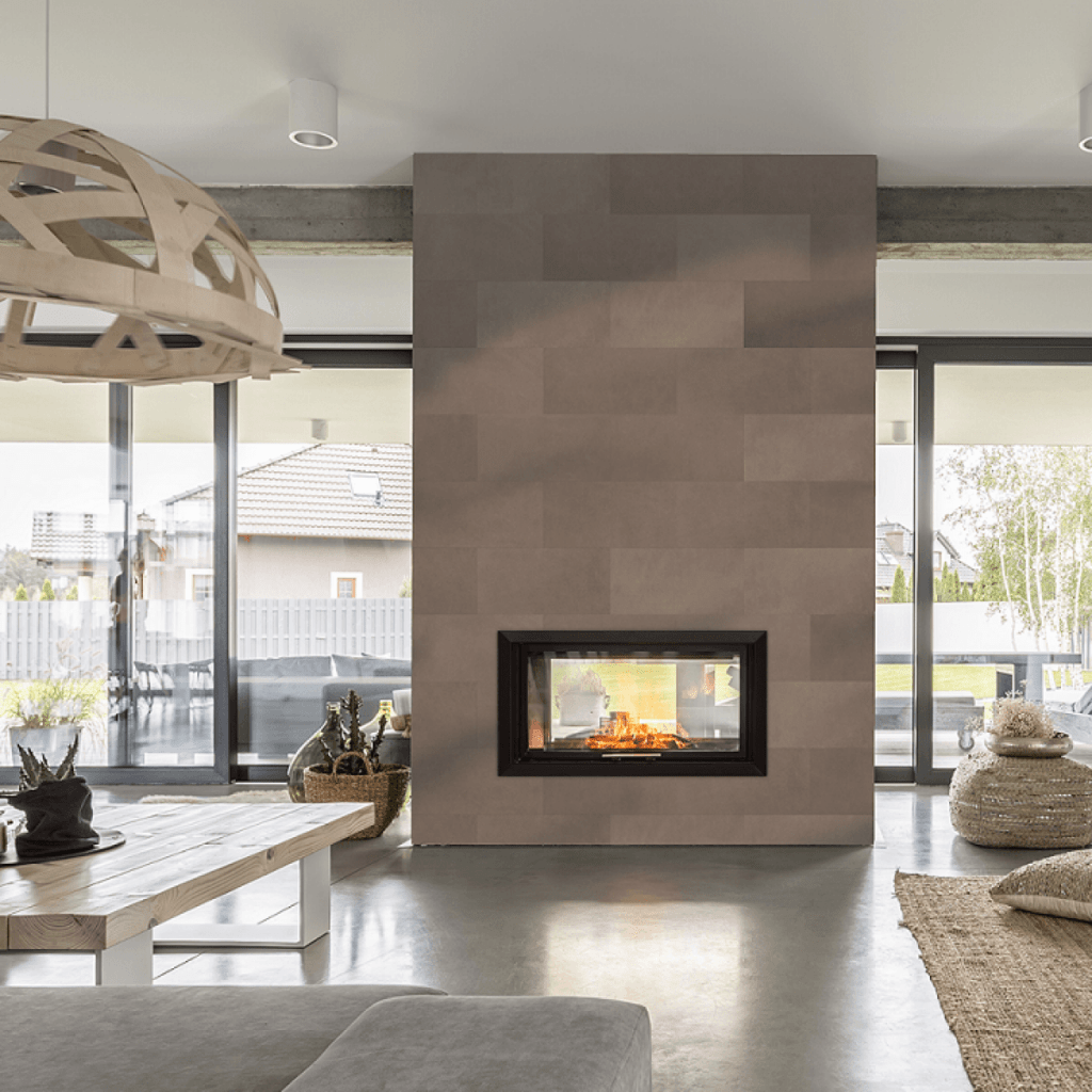 Perete cu semineu si tapet din piele, intr-un living cu ferestre mari, masa, canapea, covor si obiecte decorative