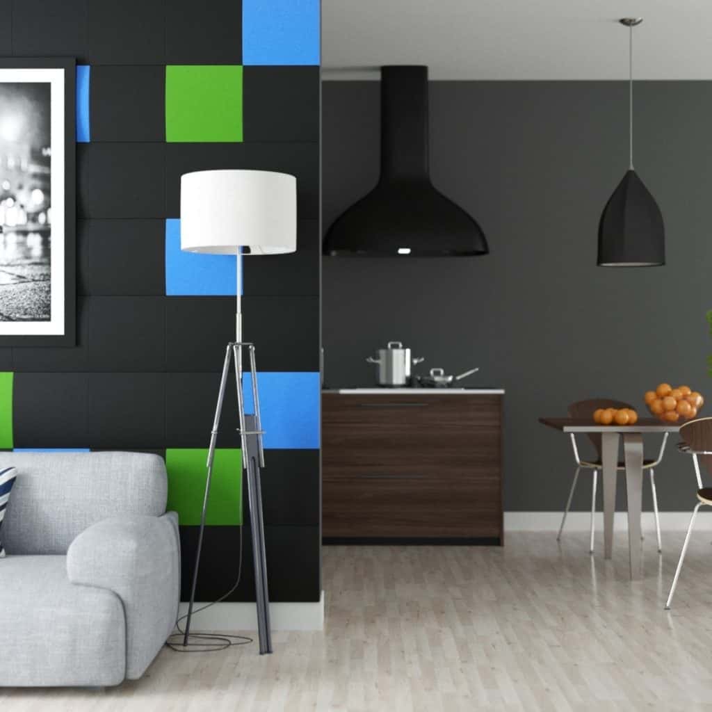 Perete amenajat cu panouri decorative din burete negru, verde și albastru, intr-o incapere cu canapea, lampa, masa si scaune