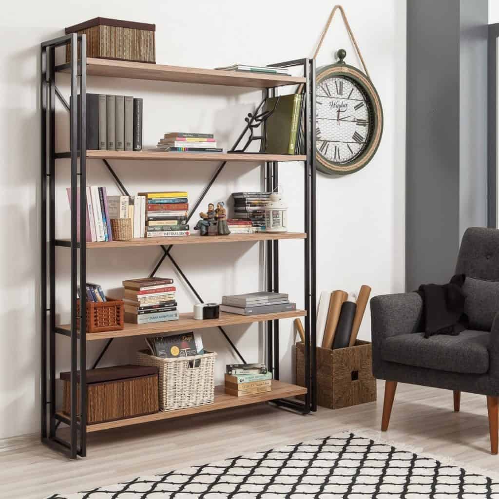 Biblioteca cu cinci rafturi pe care se afla carti, cutii si obiecte decorative, intr-o camera cu fotoliu si ceas de perete