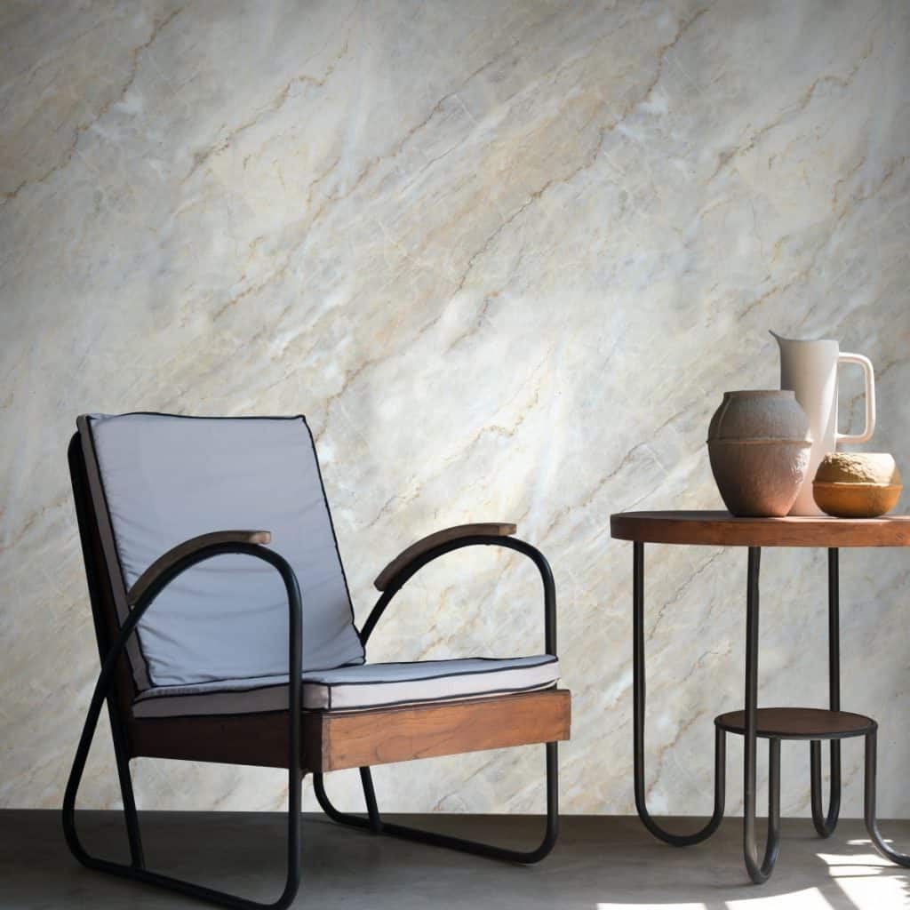 Perete cu tapet Parthenon (Warm Marble) intr-o camera cu fotoliu si masa cu vase decorative