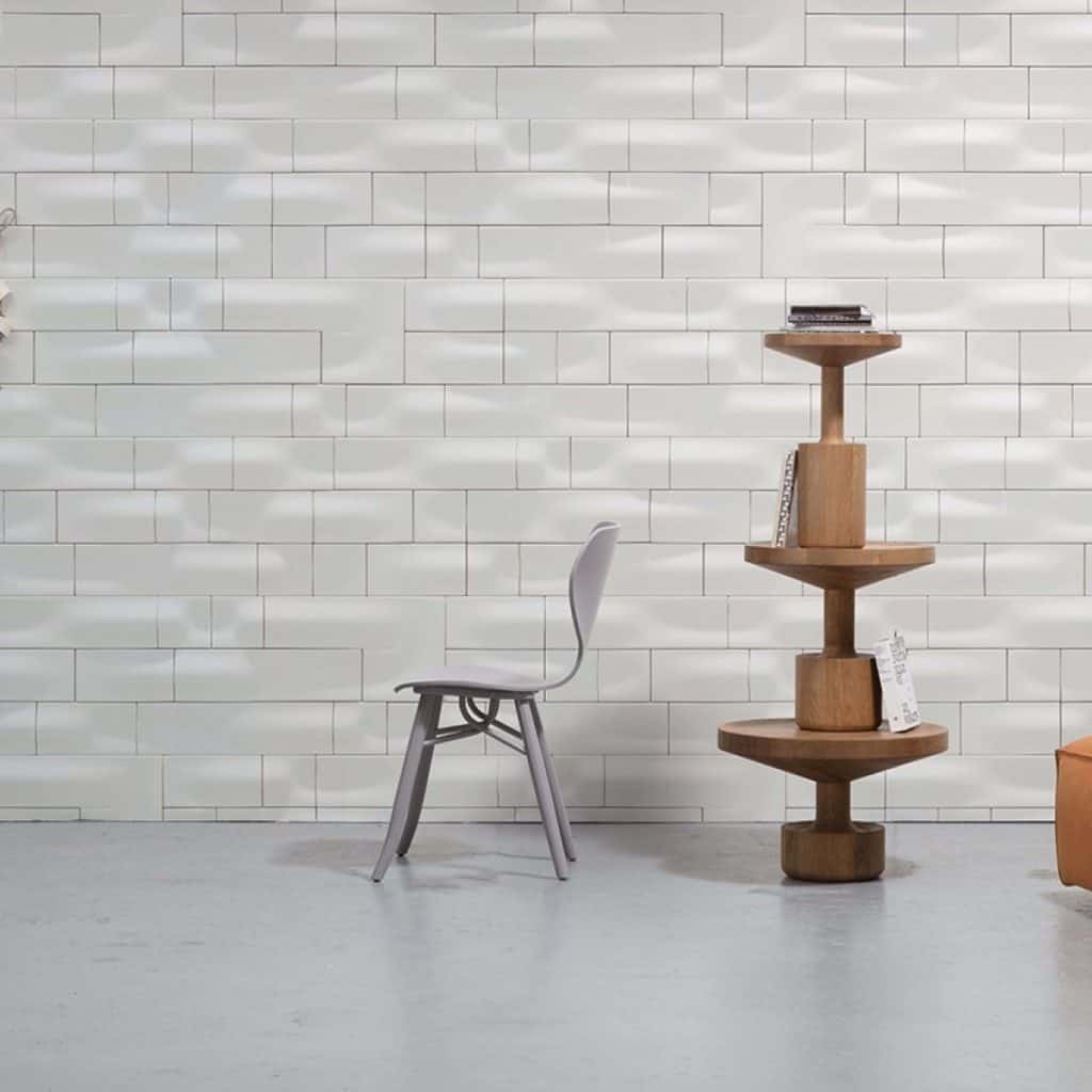 Tapet Wave Ceramics intr-o incapere cu un scaun gri si un suport decorativ din lemn