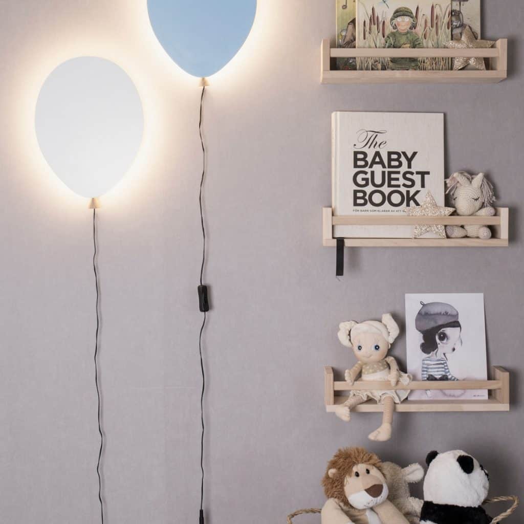Doua aplice Balon pe un perete pe care se afla mai multe polite cu jucarii
