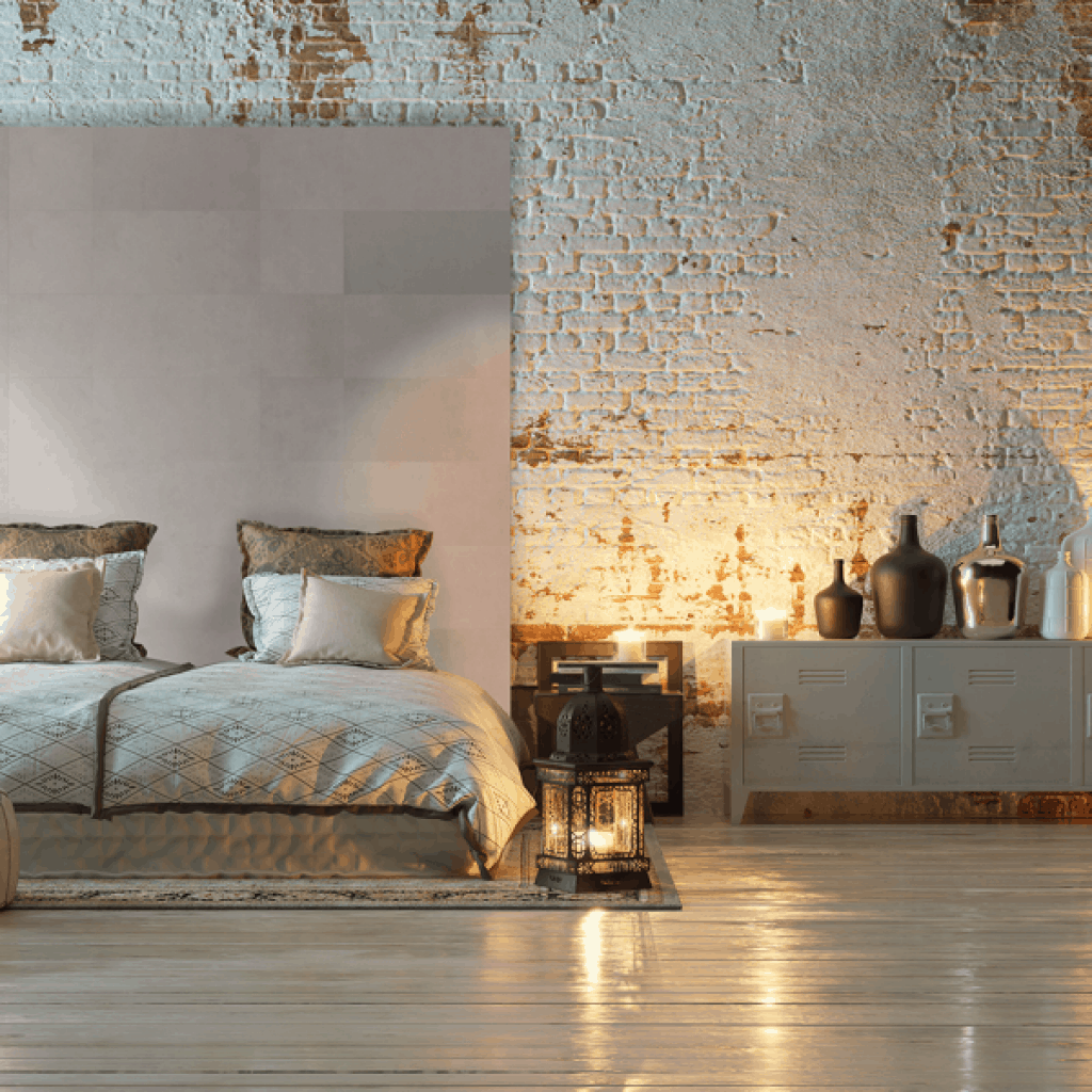 Perete cu tapet din piele Enzo Pellini Frost si caramida vopsita intr-un dormitor cu pat, noptiera cu vase decorative si lampa aprinsa