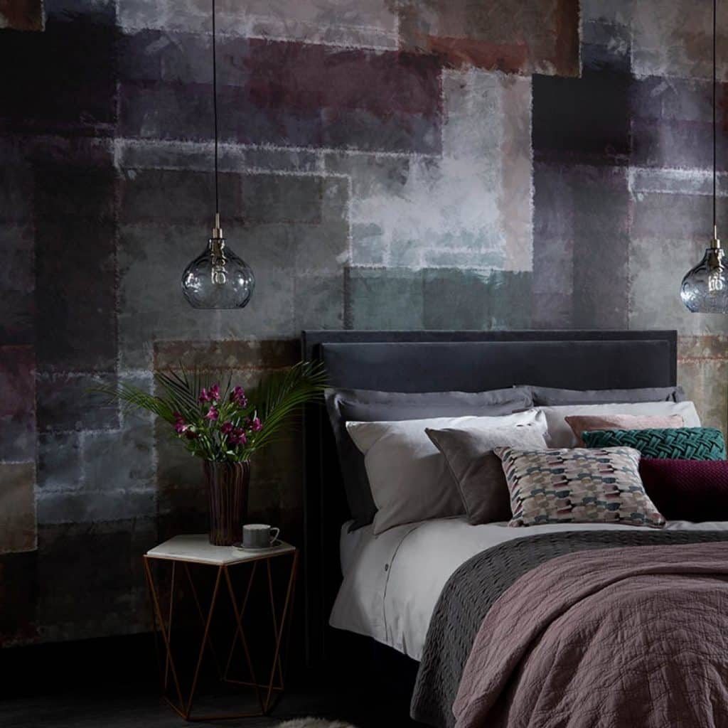 Tapet Spectrum intr-un dormitor cu pat pe care se afla mai multe perne decorative, colorate diferit