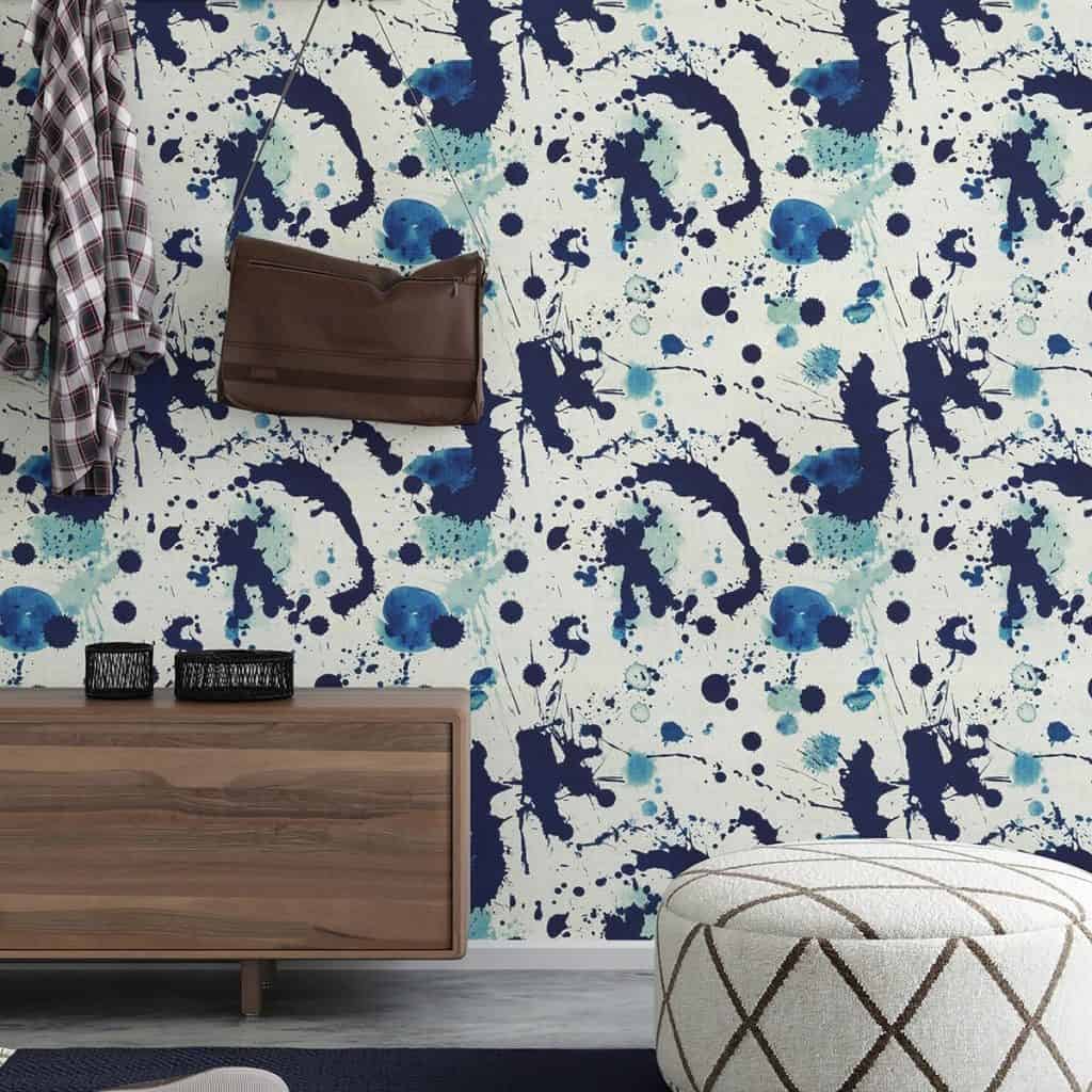 Tapet Splatters intr-un living cu comoda din lemn si un scaun rotund alb, cu forme geometrice