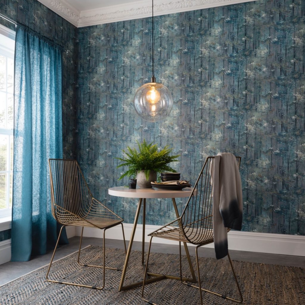 Tapet Glade intr-un living cu masa rotunda pe care se afla un vas cu planta decorativa si alte obiecte si doua scaune, cu draperii albastre la fereastra