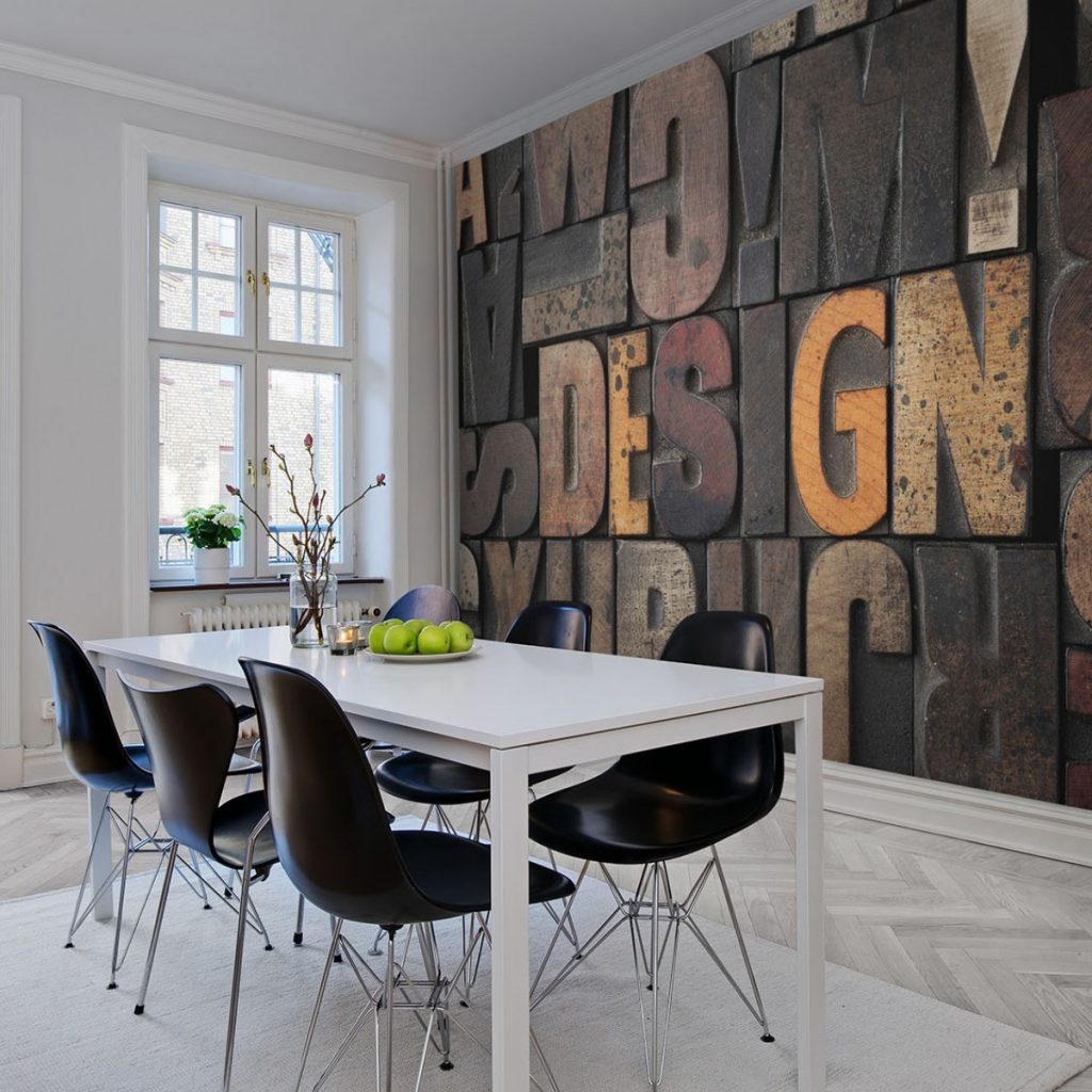 Fototapet 3D Lemn, Design, personalizat, Rebel Walls, intr-o incapere cu fereastra, parchet deschis la culoare, masa alba pe care se afla un vas cu flori si o farfurie cu mere verzi si sase scaune negre