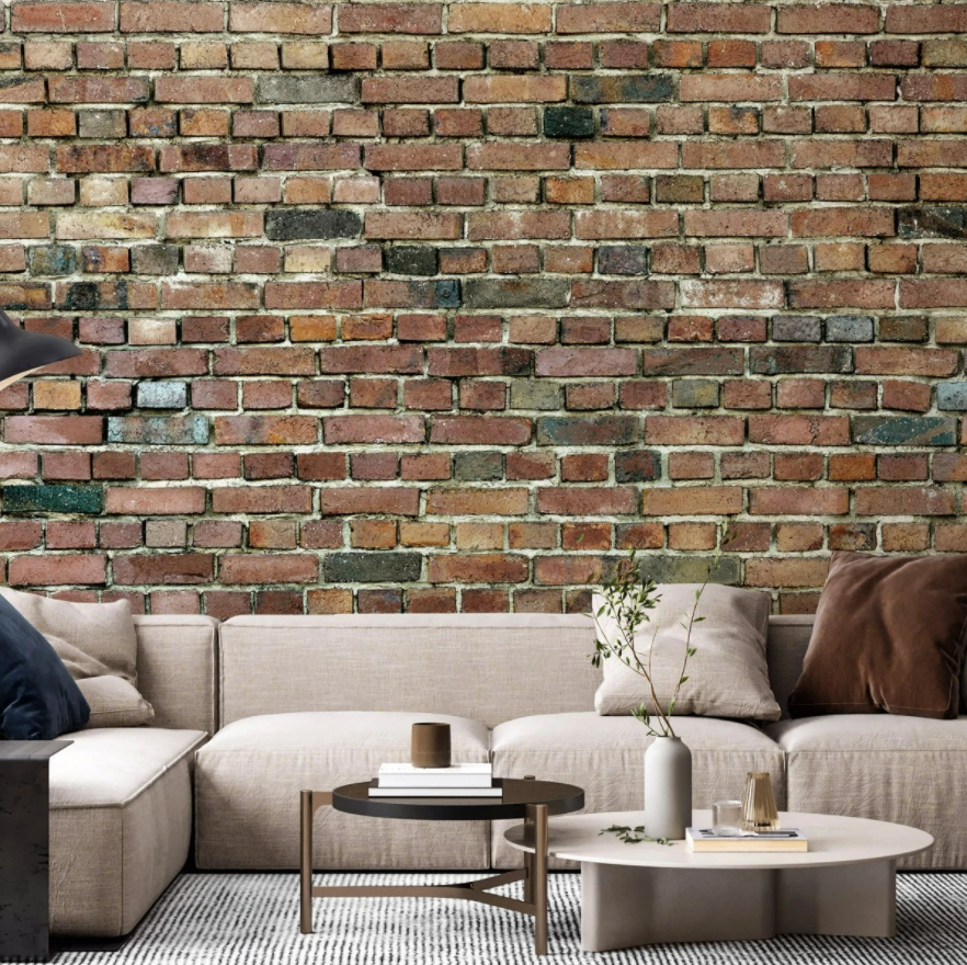 Fototapet Stockholm Brick Wall, Photowall, intr-un living cu coltar crem, cu perne decorative, doua mese rotunde de cafea, crem si maro, cu carti si obiecte decorative si covor