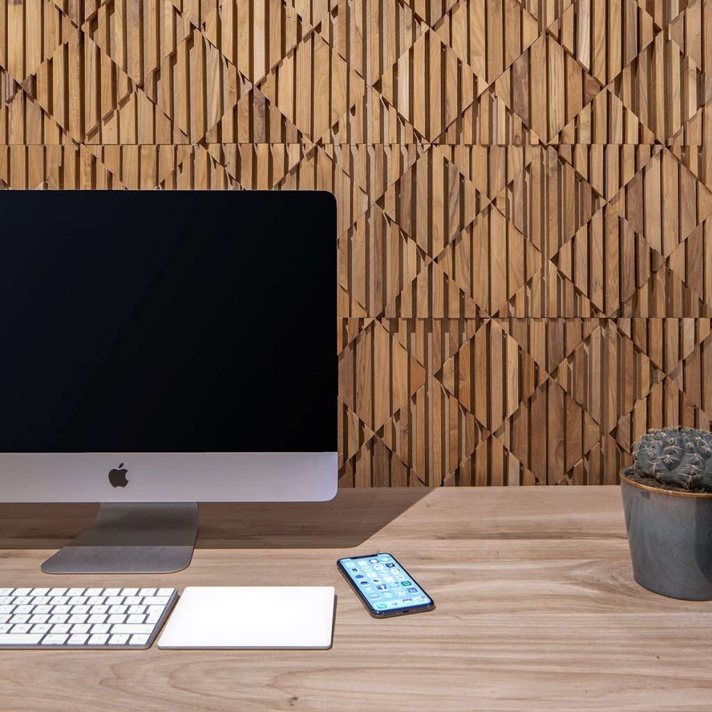 Panouri decorative 3D Tec Blend, TeakWall, in fata carora se afla un computer, un telefon si un ghiveci cu cactus