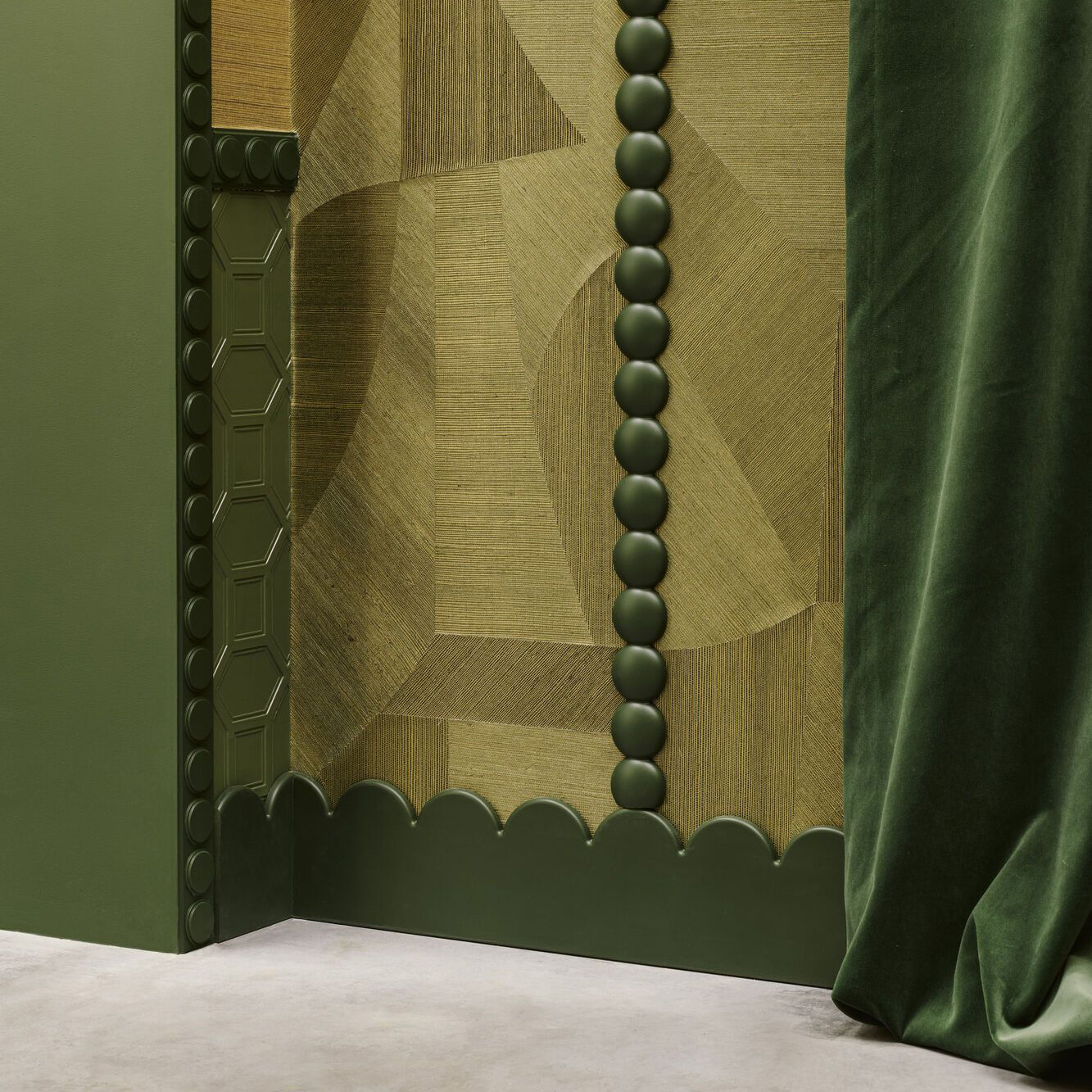 Plintă decorativă cu margine în valuri și brâu cu forme rotunde, vopsite în verde, lângă un tapet